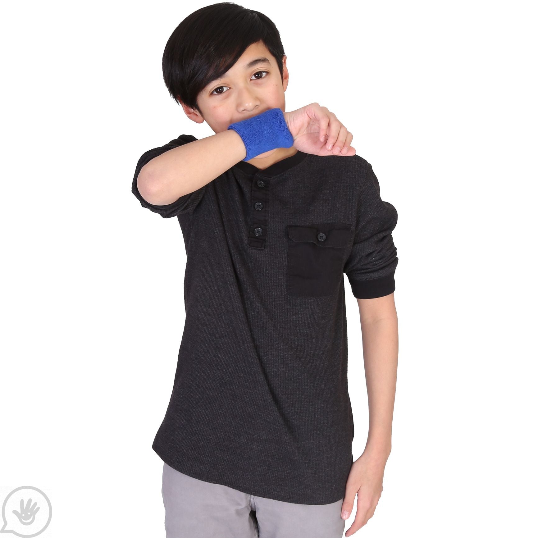 A child with light skin tone and short dark hair holds an wrist up to their mouth. They are wearing a Blue Chewy Wristband.