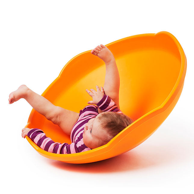 An infant is laying on their back in the Gonge Mini Top. Their legs are splayed upwards and they are looking up and to the left.