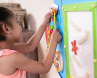 A child with medium skin tone plays with one of the puzzles on the Airplane Activity Wall Panel.