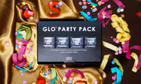 The package for Glo Party Pack Liquid-Activated Cubes sits on a table surrounded by ribbons and confetti.