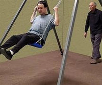 A person with light skin tone and black hair is on a swing attached to the Swing All Portable Stand. They are in a forward movement, in front of another person with light skin tone and grey hair.