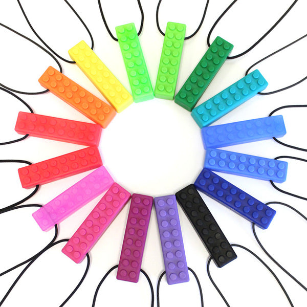The Brick Stick Chew Necklaces displayed in a rainbow circle.