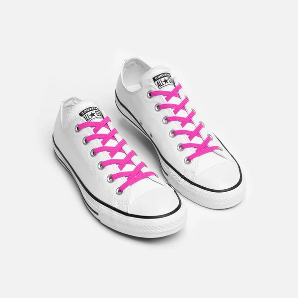 The Neon Pink Xpand No-Tie Flat Lacing System on a pair of white Converse sneakers.