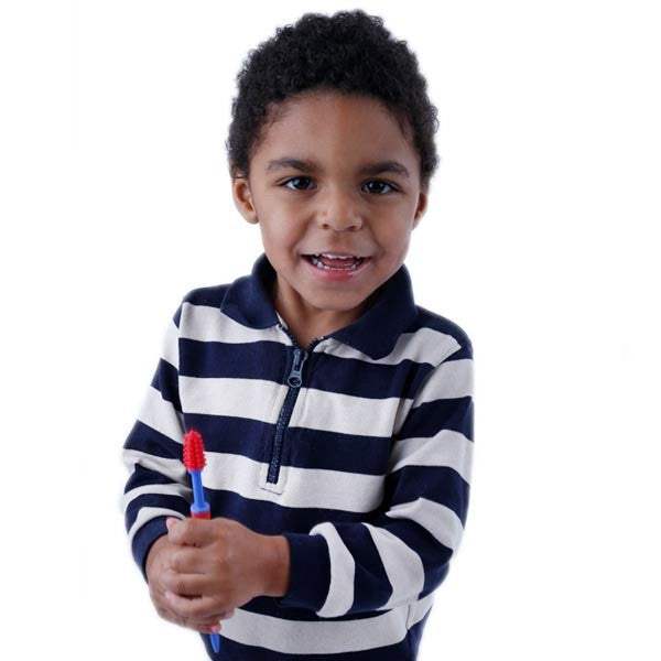 A child with dark skin tone and short black curly hair is smiling and holding a red Senso Brush.