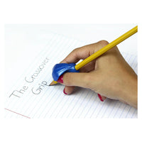 A hand with medium light skin tone and red nail polish is holding a pencil with a Crossover Pencil Grip. The hand is writing "The Crossover Grip" on a lined piece of paper.