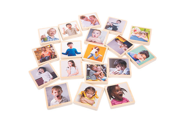 A variety of wooden tiles with images of children of different ages, ethnicities, and abilities making different expressions.