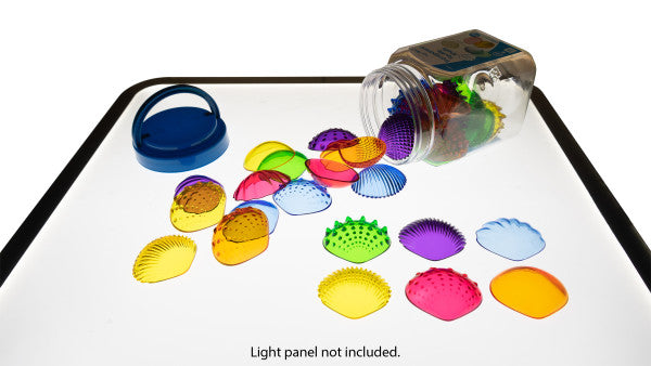 A display of many colors and textures of Transparent Tactile Shells spilling out of their package onto a light box.